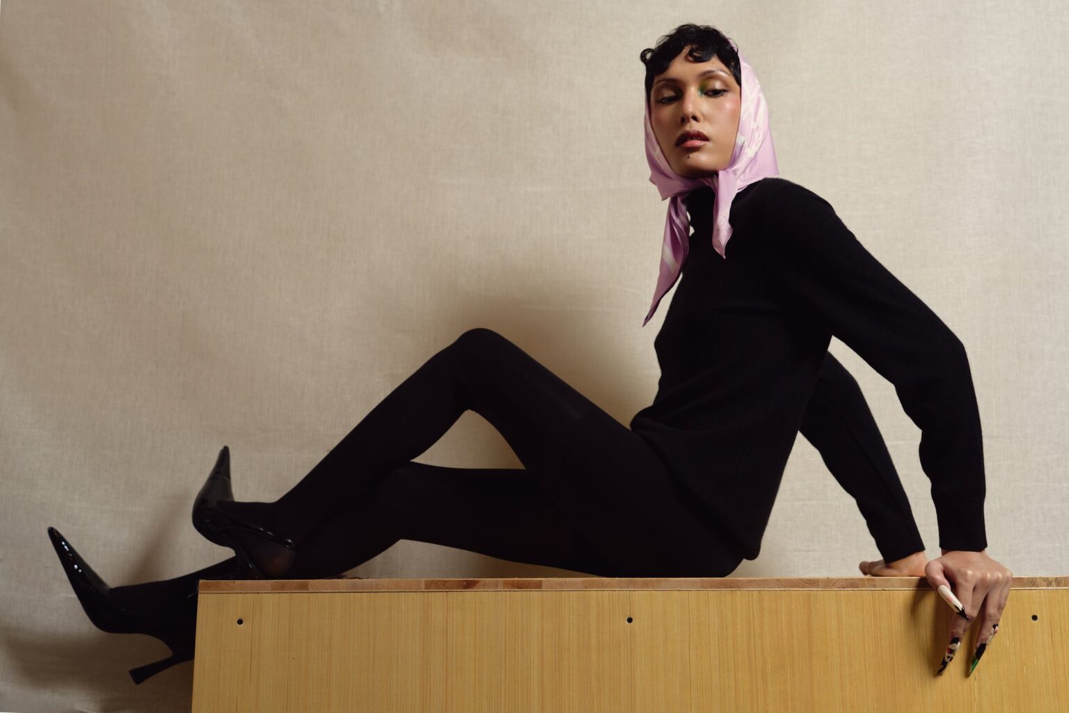 Model in the lavender Solar Village headscarf seated on a wooden bench