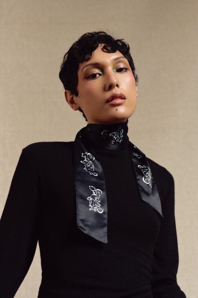 Model wearing the black Motor skinny scarf tied at the neck