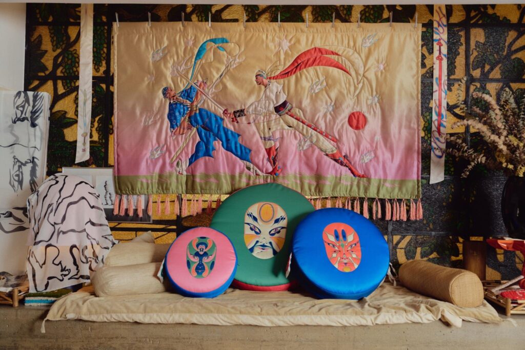 Swordfight Tapestry hanging above a group of quilted mask cushions